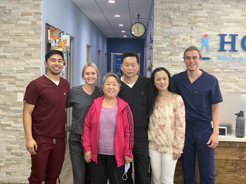 HOPE Clinic team and patient group photo in front of clinic sign