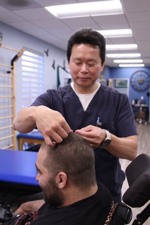 Dr. Lu performing acupuncture on patient in clinic treatment room