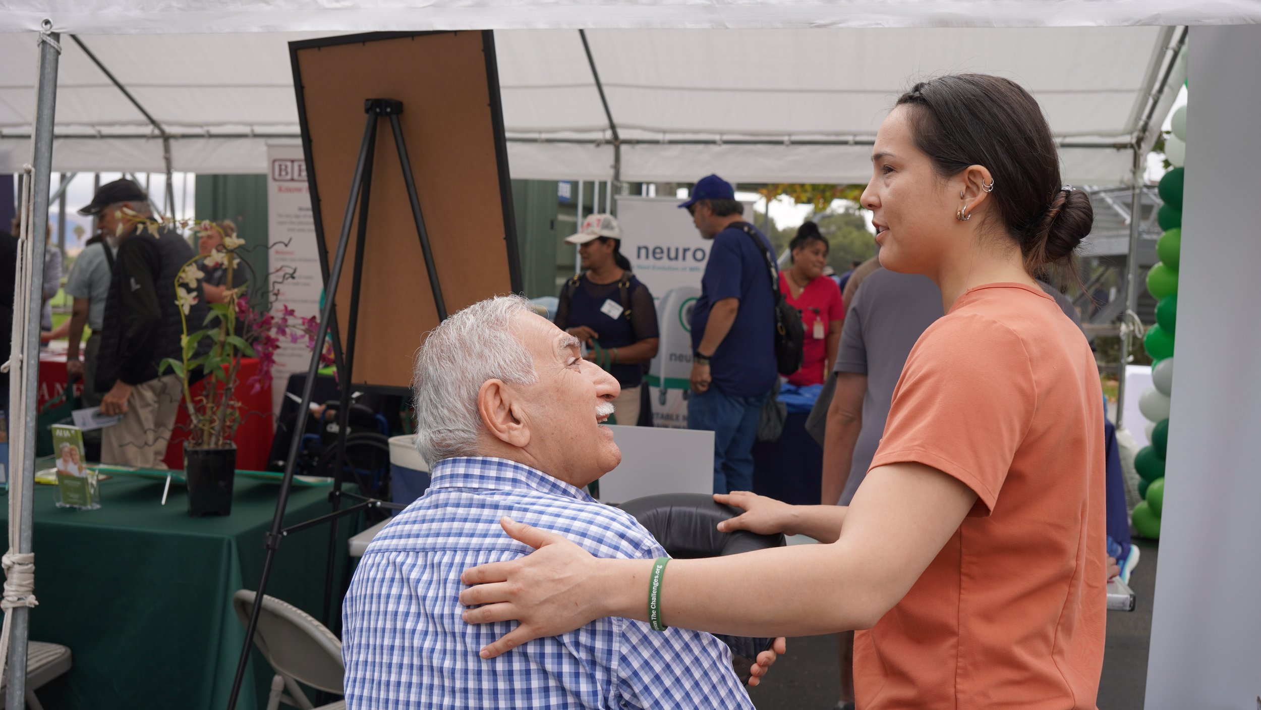HOPE therapist greeting smiling elderly man at community stroke awareness event