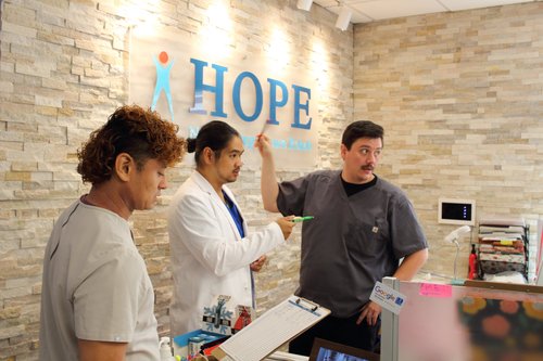 Staff members coordinating patient care at HOPE Clinic front desk