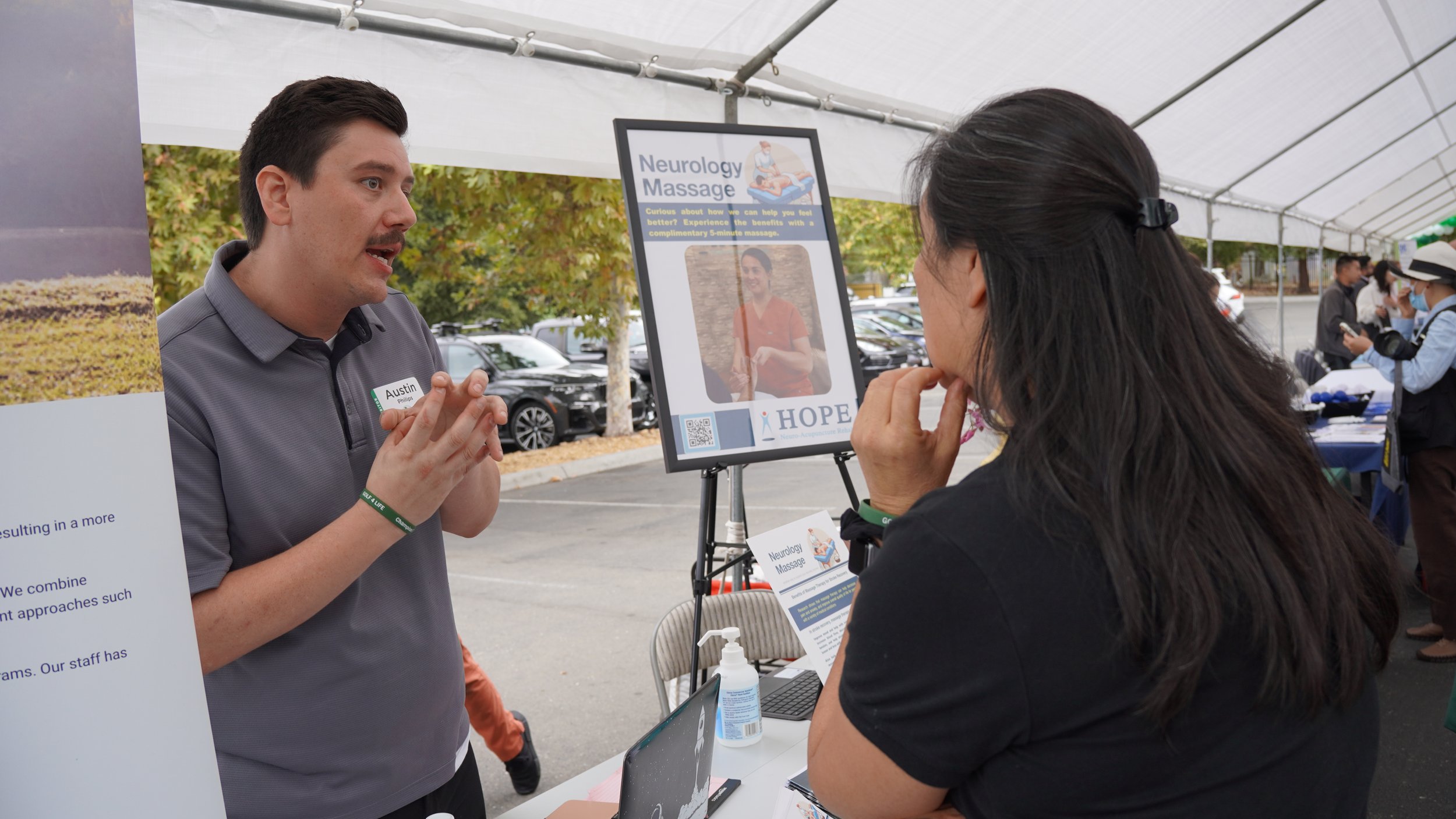 HOPE Clinic staff member discussing treatment options with visitor at community event