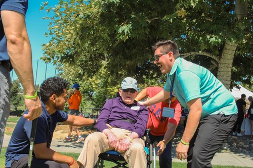 HOPE team members assisting wheelchair patient at outdoor community health event