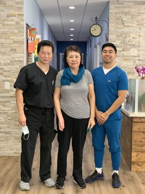 Dr. Lu with patient and family members posing in clinic hallway
